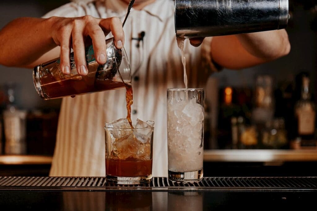 Alex pours two cocktails at Ponyboy